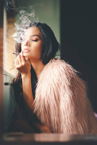 Portrait of sexy asian woman is smoking - Foto, afbeelding