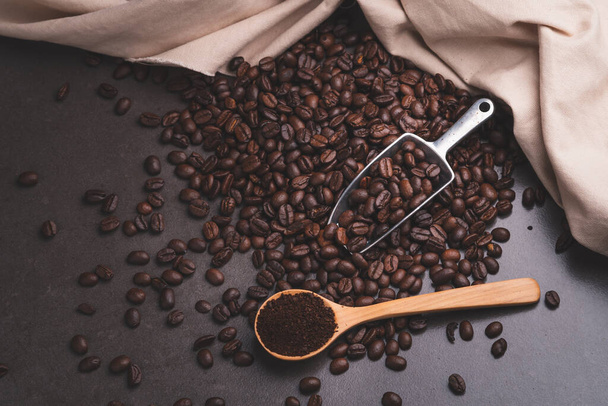 Kahverengi arka planda kaşık kahve çekirdekleri - Fotoğraf, Görsel