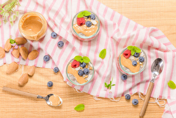 Chia pudding with oat and berries in a glass jar on rustic background. - Foto, Bild