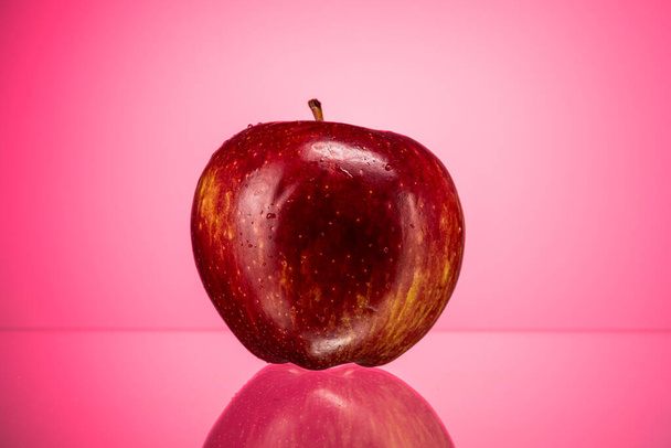 ώριμο κόκκινο μήλο χρυσό simirenko σε φόντο κόκκινη κλίση - Φωτογραφία, εικόνα