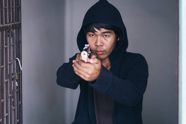 Homem usar mangas compridas com capuzes carregando arma em suas mãos
. - Foto, Imagem