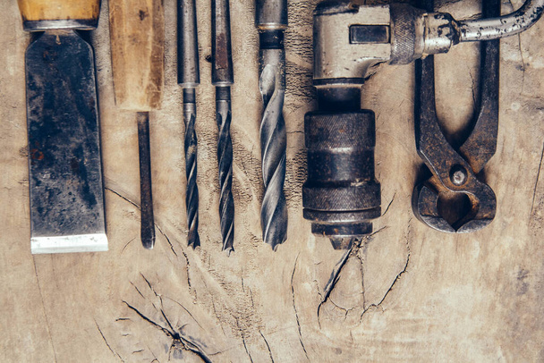 Las viejas herramientas de construcción sobre un banco de trabajo de madera plano yacen en el fondo. Mesa de carpintero. Carpintería - Foto, Imagen