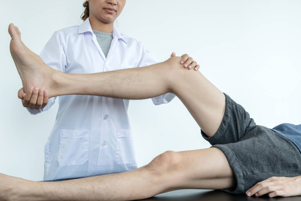 I pazienti di sesso maschile consultavano fisioterapisti con problemi al ginocchio per l'esame e il trattamento. Concetto di fisioterapia riabilitativa. - Foto, immagini