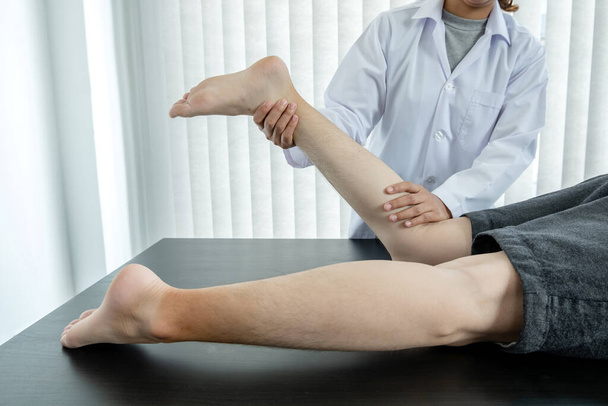 Пациенты мужского пола консультировались с физиотерапевтами с проблемами коленного сустава для обследования и лечения. Концепция реабилитационной физиотерапии. - Фото, изображение