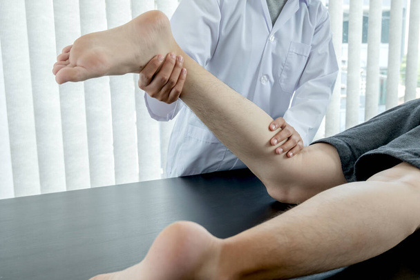 Pacienti mužského pohlaví konzultovali fyzioterapeuty s problémy s bolestí kolene pro vyšetření a léčbu. Rehabilitační fyzioterapeutický koncept. - Fotografie, Obrázek