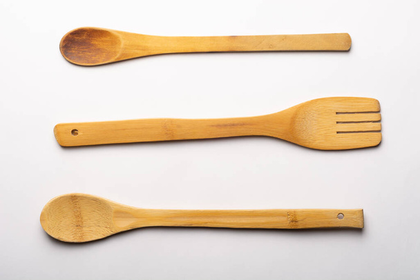 Vintage Wooden Spoons and Fork on White Textured Paper. Kitchen and Cooking Concept. - Фото, изображение