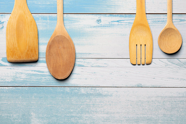 Cucchiai di legno, forchetta e agitatore su tavolo di legno turchese. Concetto cucina e cucina
. - Foto, immagini
