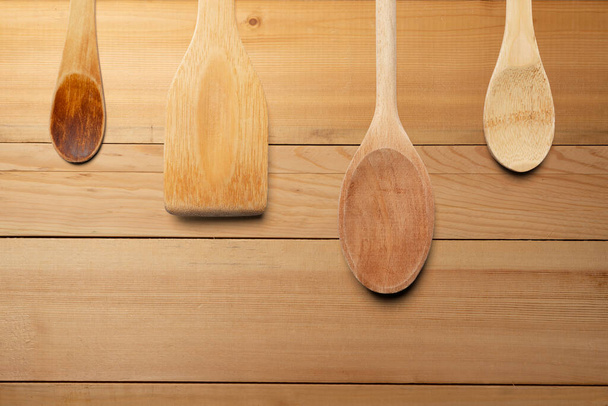 Wooden spoons and stirrer on wooden table. Kitchen and cooking concept. - Photo, Image
