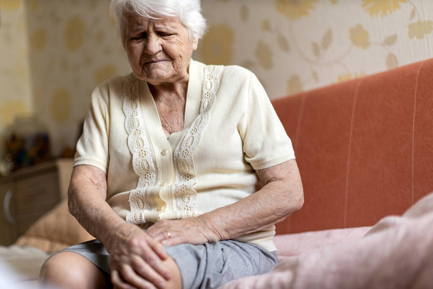 vanhempi nainen, jolla on polvikipu
 - Valokuva, kuva