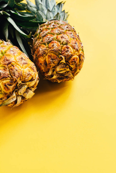 fresh ripe pineapples on yellow background with copy space - Valokuva, kuva
