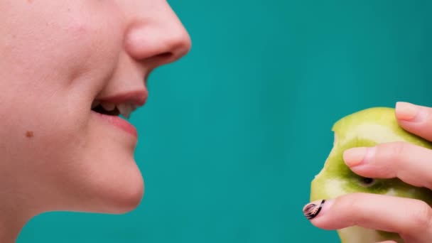 Egészséges táplálkozás és egészséges fogak vagy étrend, fiatal nő harap egy friss alma a zöld képernyőn közelkép - Felvétel, videó