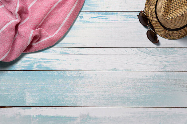 Towel. Scarf. Cover for picnic. Sunglasses. Straw hat. Summer travel concept elements. On turquoise wooden table. Top view. - Photo, Image