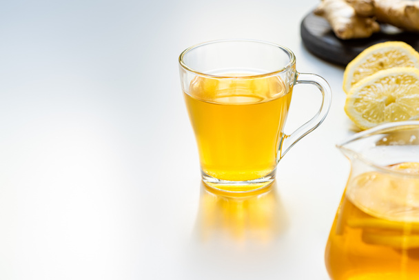 valikoiva painopiste kuumaa teetä lasi kuppi sitruuna viipaleita valkoisella pohjalla - Valokuva, kuva