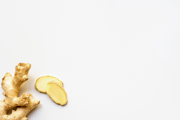 top view of whole ginger root and slices on white background - Foto, Imagen