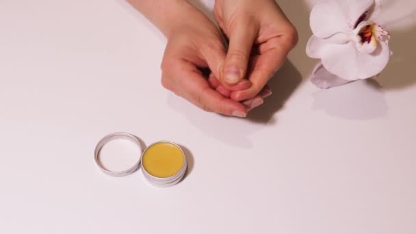 Das Mädchen reibt Wachsöl in die Nagelplatte. Nägel und Nagelhautpflege stärken. - Filmmaterial, Video
