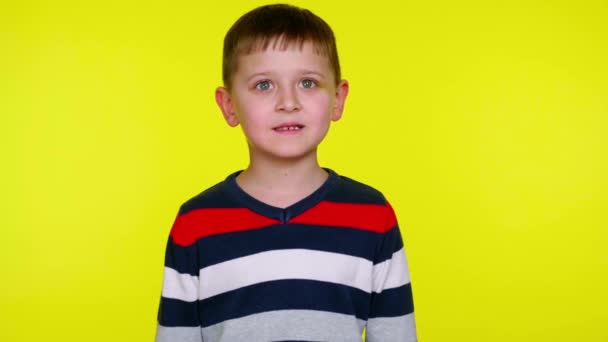 Mały chłopiec warczy na żółtym tle z przestrzenią do kopiowania - Materiał filmowy, wideo