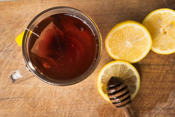 Tratamento frio natural e remédios em fundo de madeira. Chá quente com limão orgânico e mel
. - Foto, Imagem