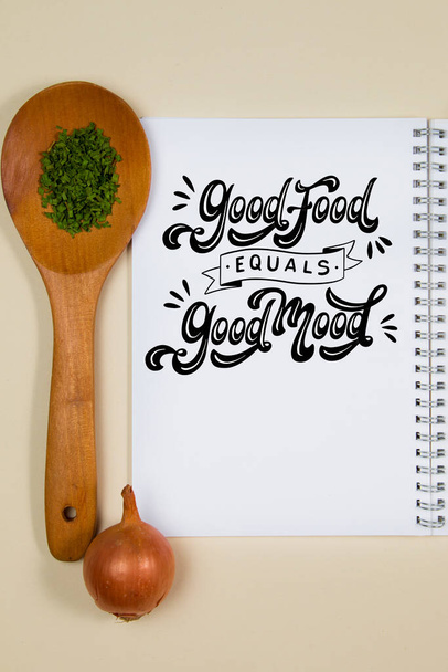 Wooden ladle with some herb spice and a blank notebook page - Foto, afbeelding