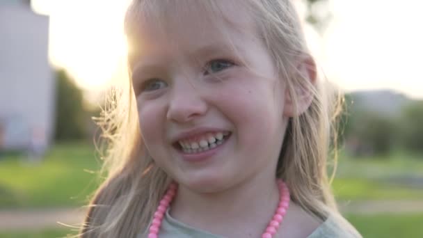 Крупним планом смішна дівчинка серед заходу сонця в літньому парку
 - Кадри, відео