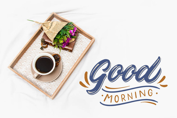 Fresh morning coffee on a board on a bed sheet with the text - Фото, зображення