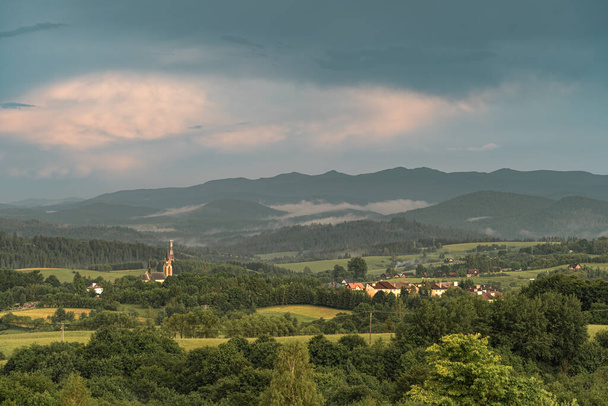 Туман спускається з гірського пасма до села на заході сонця. Пейзаж з Лутовиски в горах Біскаді (Польща)..  - Фото, зображення