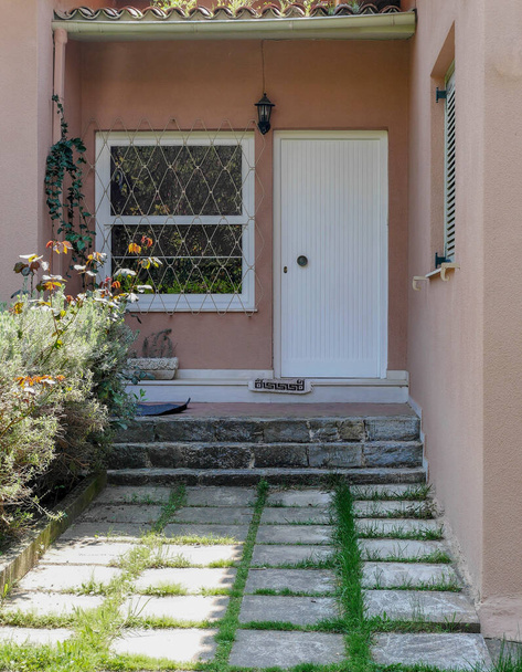 διάδρομο στην είσοδο του σπιτιού με φυτά, λευκή πόρτα και παράθυρο - Φωτογραφία, εικόνα