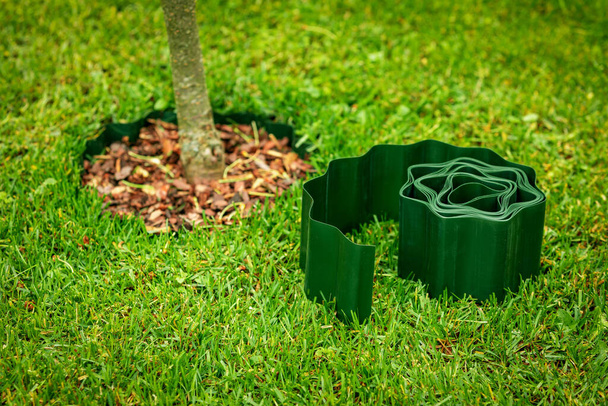 green plastic lawn edge tape for flowerbed and tree edging - Photo, Image
