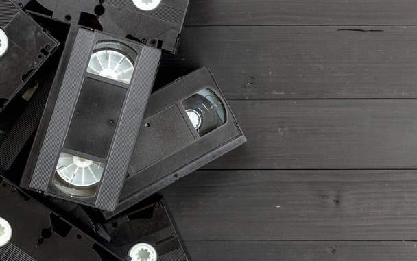 old video tape on black wooden background. top view - Fotoğraf, Görsel