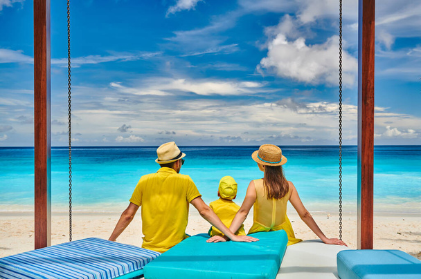 Perhe kauniilla Petite Anse rannalla, nuori pari keltaisessa kolmen vuoden ikäisen taaperopojan kanssa. Kesäloma Seychelleillä, Mahe
. - Valokuva, kuva
