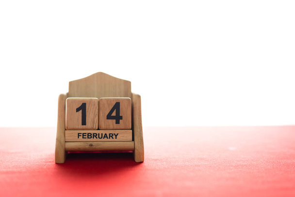 valentine's day concept. wooden calendar 14 February with soft-focus and over light in the background - Fotó, kép