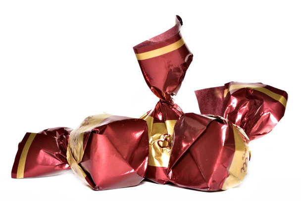Doces de chocolate envoltos em envoltório decorativo brilhante
 - Foto, Imagem