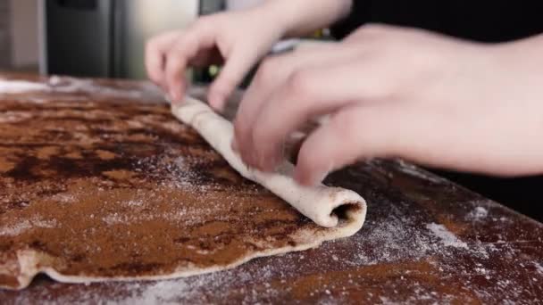 μια μαγείρισσα στριφογυρίζει τη ζύμη με κανέλα - Πλάνα, βίντεο