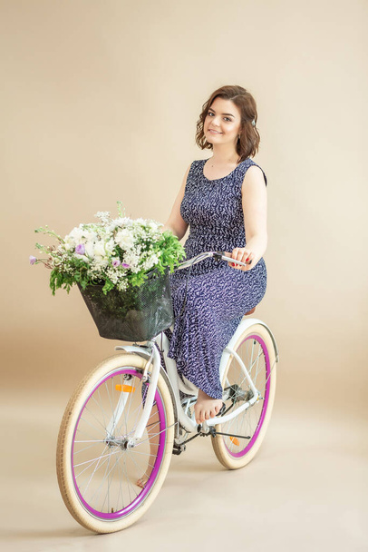 Uma mulher a andar de bicicleta. Menina bonito em um vestido de verão
. - Foto, Imagem