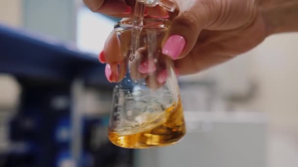 Scientist hand shakes up lab flask. Chemical laboratory experiment. - Video, Çekim