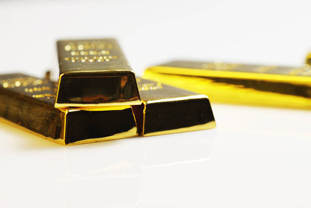 Gros plan sur 999,9 lingots de lingot d'or pur empilés sur fond blanc, représentait l'idée de concept d'entreprise, d'investissement et de finance
 - Photo, image