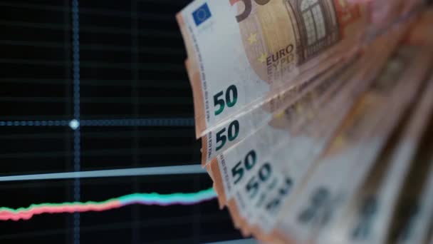 Європейська паперова валюта на тлі чартів, торговець, який утримує 50 євро. Аналіз і статистика даних, крах фондового ринку. Втрата активів і акцій, концепція інфляції і фінансової кризи в - Кадри, відео