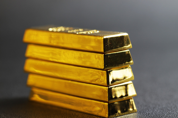 close up shot of stacked 999.9 pure gold bar ingot on a black background, represented the business, invesment and finance concept idea - 写真・画像