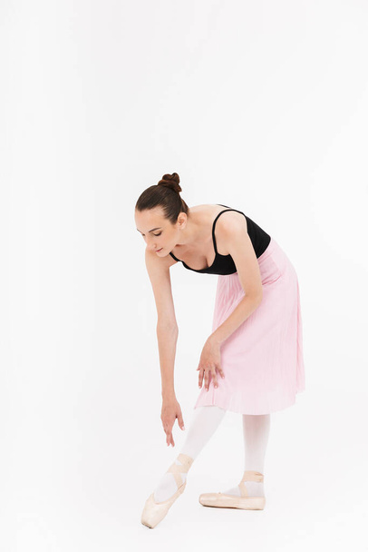 Image of caucasian young woman ballerina practicing and dancing gracefully isolated over white wall background - Fotografie, Obrázek