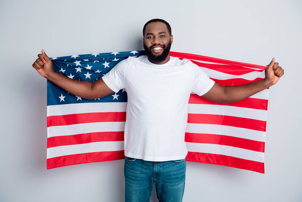 Foto van vrolijke vriendelijke donkere huid Afrikaanse man demonstrant verhogen Amerikaanse nationale vlag zwarte mensen revolutie liefde alle mensen uit te drukken eenheid solidariteit geïsoleerde grijze kleur achtergrond - Foto, afbeelding