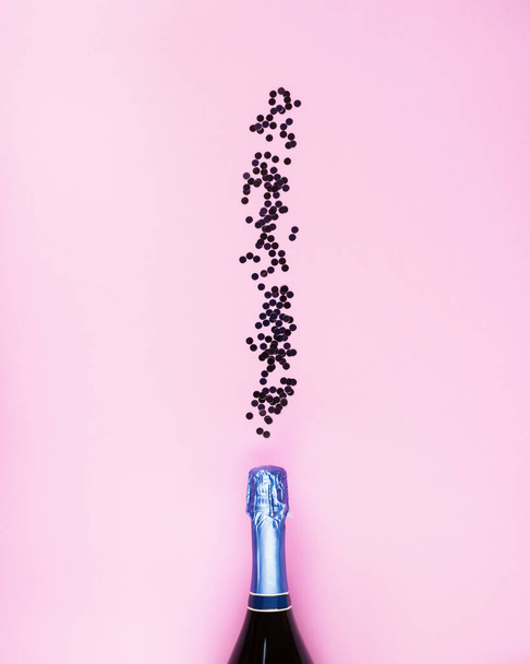 Σαμπάνια μπουκάλι και κομφετί ροή σε ροζ - Φωτογραφία, εικόνα