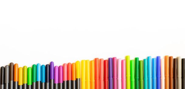 Набір різних кольорових маркерів, розміщених пліч-о-пліч, в самому низу фото з копіювальним простором. Біле тло - Фото, зображення