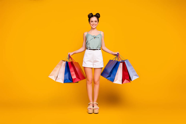Full length photo of positive cheerful girl addicted shopper buy many purchases hold bags wear tank top high heels sandals isolated over bright shine color background - Foto, Imagem