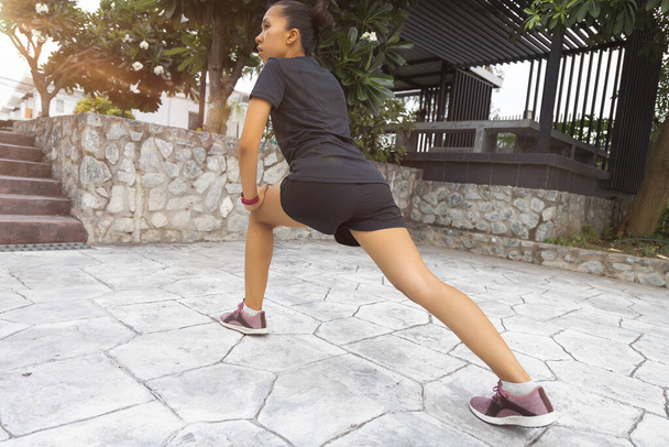 Młode kobiety ćwiczą przed treningiem fitness w parku. Zdrowa młoda kobieta rozgrzewa się na zewnątrz. - Zdjęcie, obraz