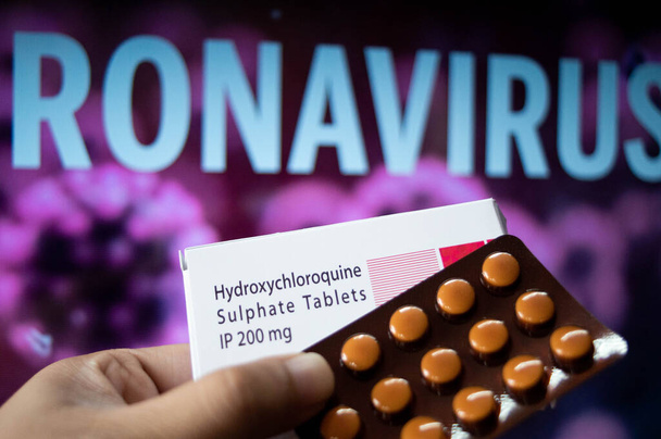 Hydroxychloroquine Sulfate comprimés avec coronavirus écrit en arrière-plan - Photo, image