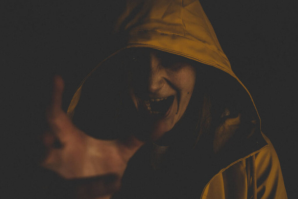 pehmeä painopiste melua tyttö muotokuva pelästyttää ilme Halloween käsite kasvot valokuvaus keltainen sadetakki pimeässä valaistus - Valokuva, kuva