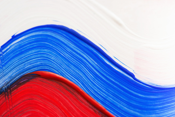 Russian flag in acrylic close-up. Smears in the colors of the Russian tricolor. Russia day on June 12. State symbol. Creative background. Closeup of painting with acrylic paints. - 写真・画像