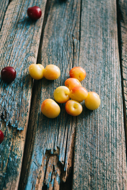 Fresh homemade ripe cherries on a wooden old background. Summer still life - Фото, изображение