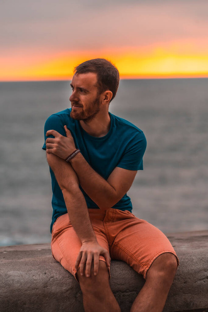 portrait of handsome man relaxing at sea shore at sunset  - Fotó, kép