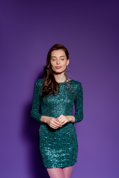 young woman in party dress standing on purple  - Foto, Bild