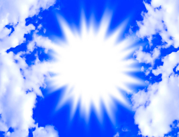 Oslnivý záblesk světla na jasně modré obloze rámované načechranými bílými mraky. - Fotografie, Obrázek